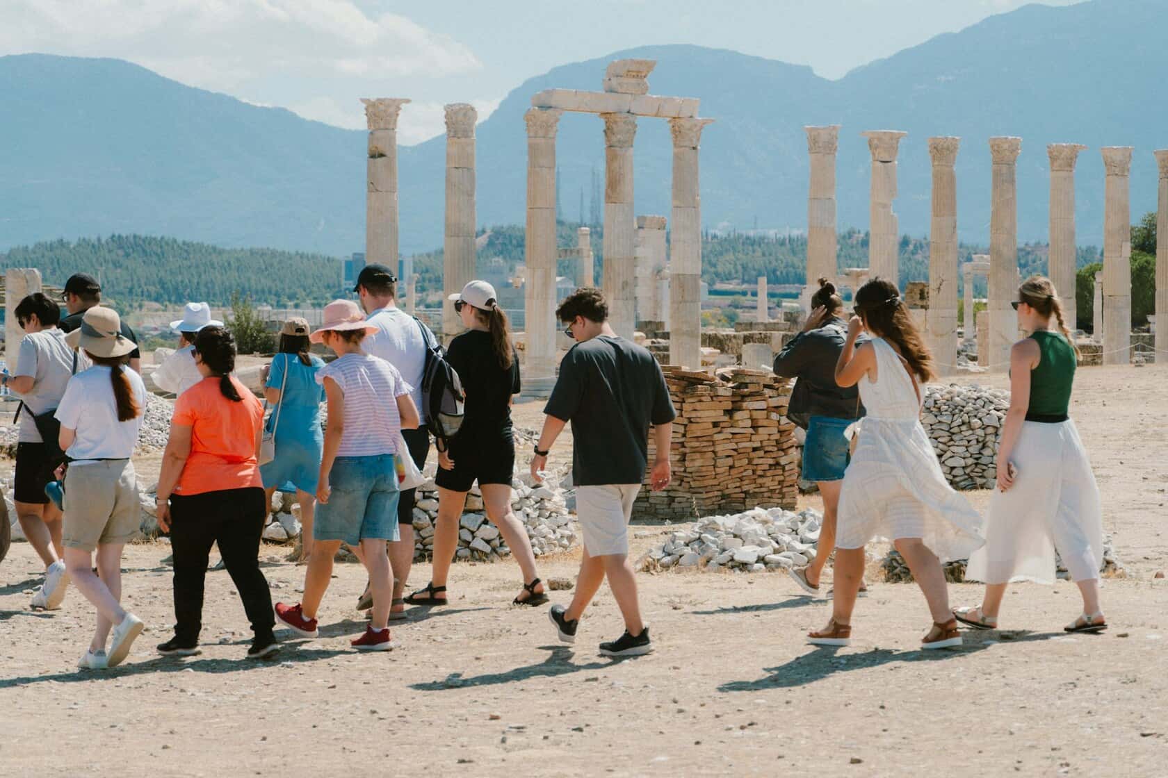 A tour group walking through hilltop ruins on a clear day