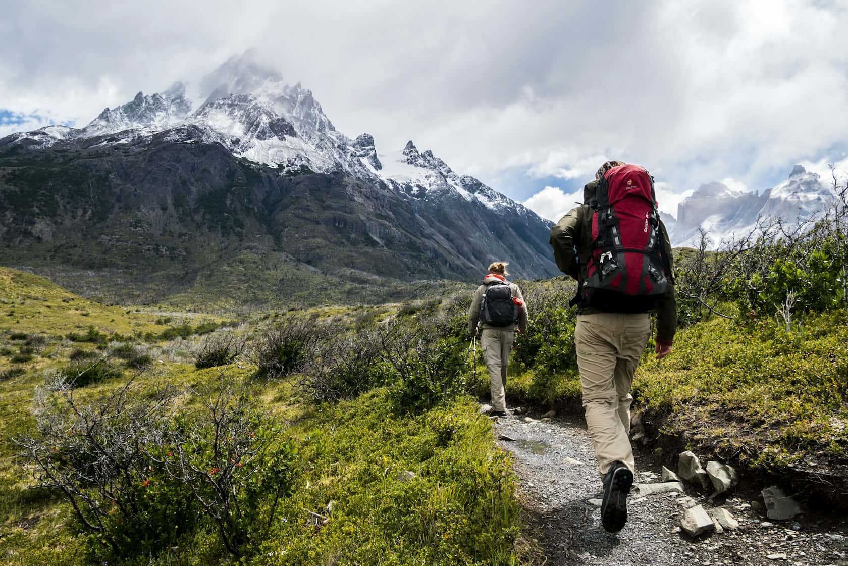 A small trekking group on a mountain trail, packs on