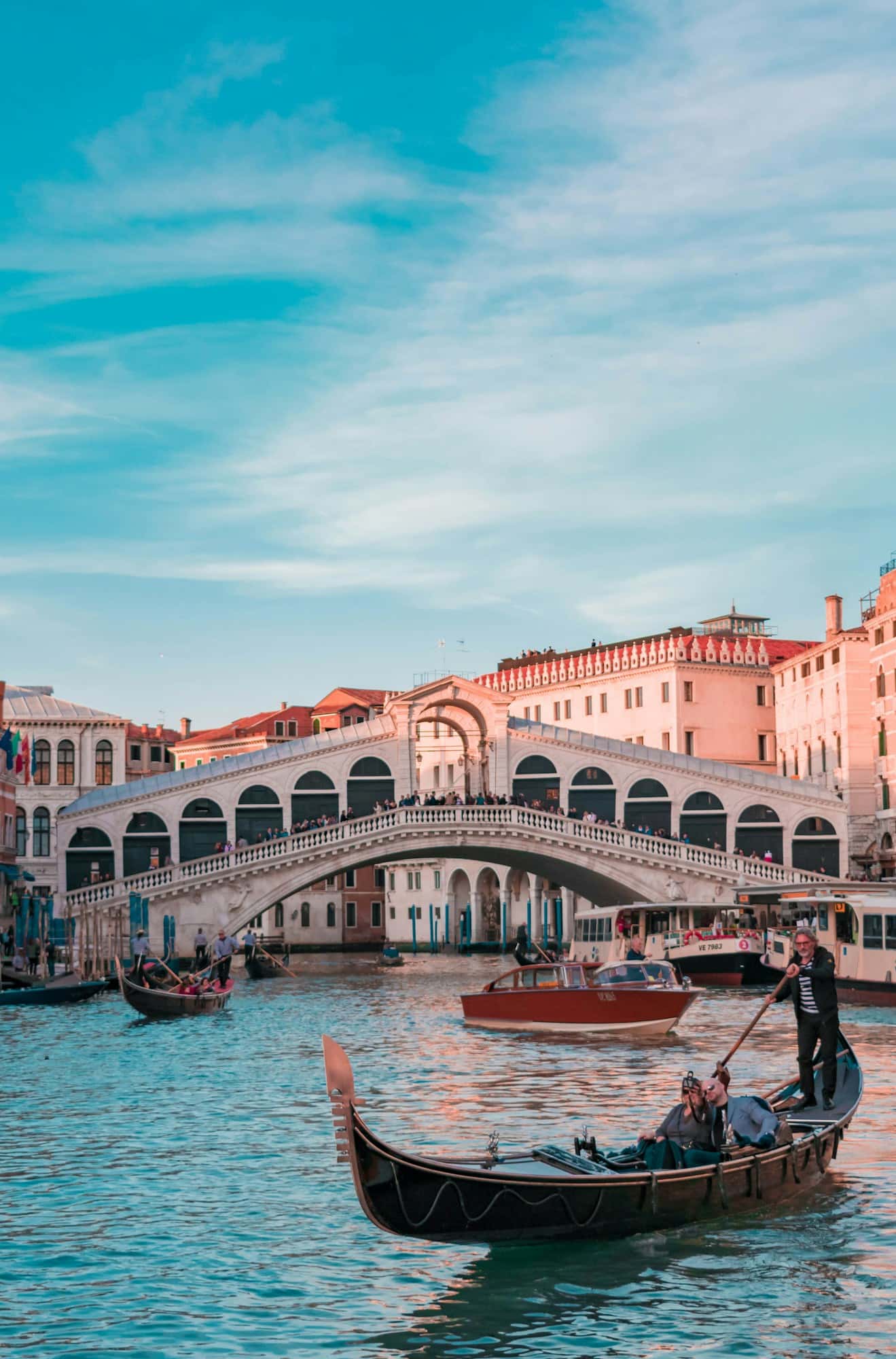 An old-town canal crossing busy with travelers